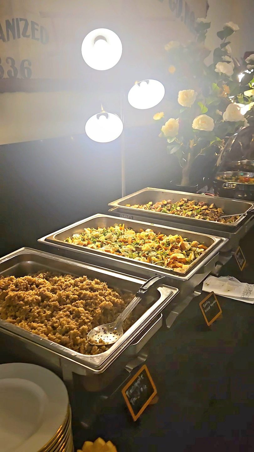Buffet line with three chafing dishes filled with rice, mixed vegetables, and potatoes.